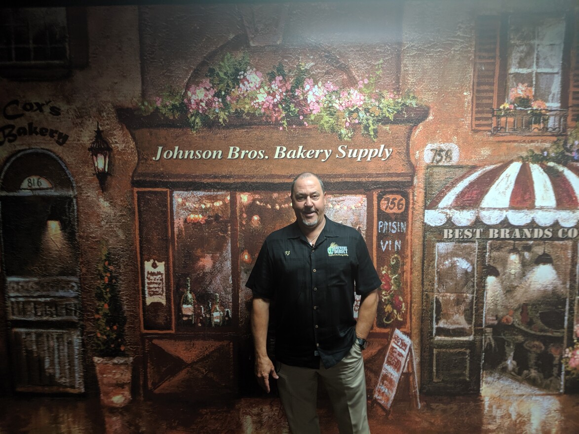 Kevin Johnson, 59, stands in front of a mural of the company's history.